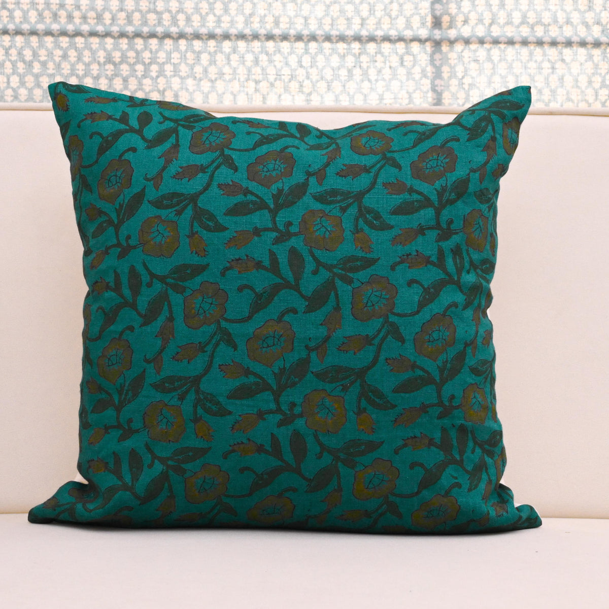 Teal wild rose vine block print linen pillow cover styled on a sofa